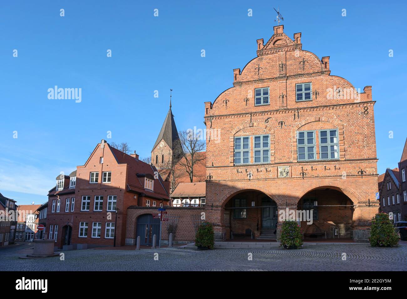 Marktplatz in der Stadt Gadebusch mit dem mittelalterlichen Rathaus und der Kirche in roter Backsteinarchitektur gegen einen klaren blauen Himmel mit Kopierraum, Meckl Stockfoto