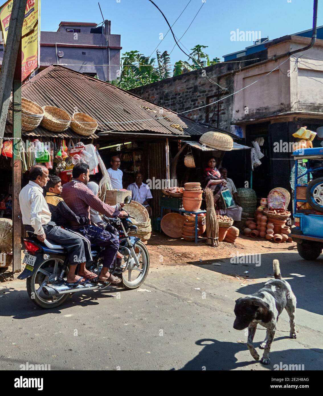 Kalna, Westbengalen, Indien. Typische Atmosphäre im Zentrum mit seinen Ständen entlang der Straße. Händler von Körben, verschiedene Töpfereien und Verkehr auf der st Stockfoto