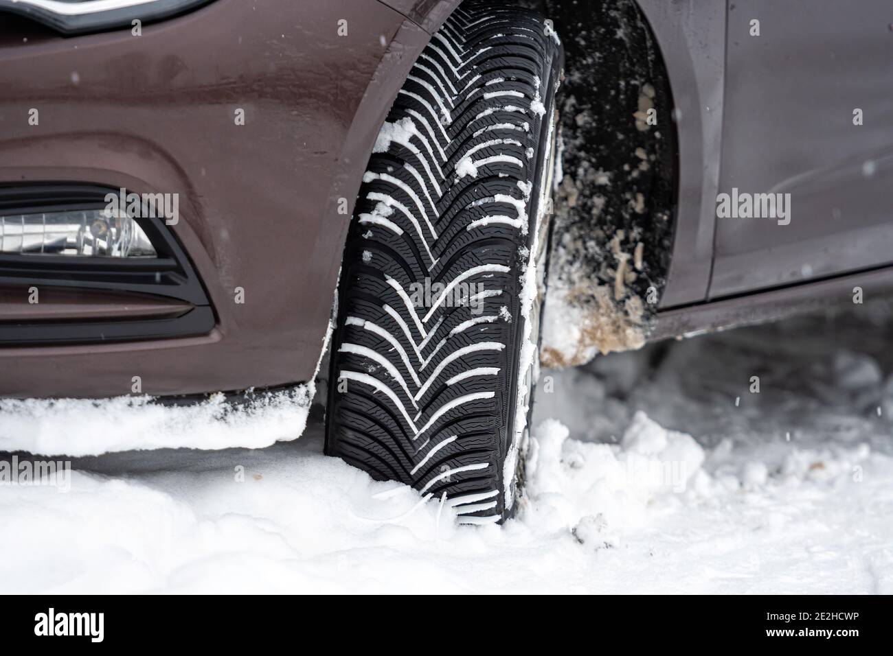 Auto mit Winterreifen in verschneiten Outdoor-Straße, Reifen im Winter auf Schnee, Nahaufnahme Stockfoto