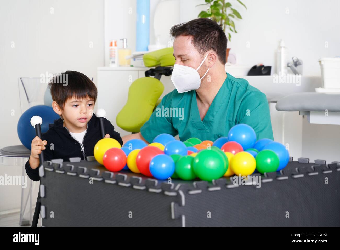 Kind mit zerebraler Lähmung auf Physiotherapie in einem Kindertherapiezentrum. Junge mit Behinderung macht Übungen mit Physiotherapeuten in Reha-Zentrum. Hochwertige Fotos. Stockfoto