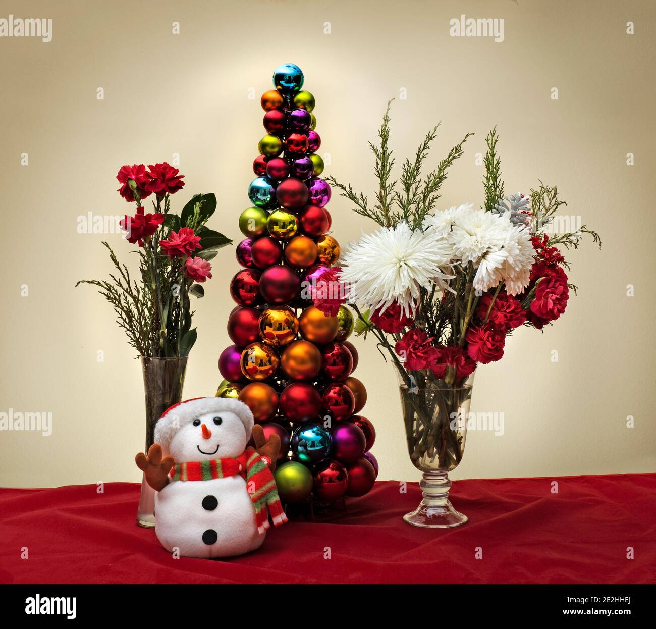 Weihnachtsszene mit Blumen Schneemann und weihnachtsbaum aus Glänzende dekorative Kugeln Ornamente Stockfoto