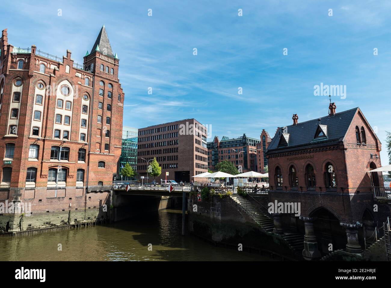 Hamburg, Deutschland - 23. August 2019: Alte Lagerhäuser in Büros und Wohnungen umfunktioniert, direkt am Kanal mit Menschen in der HafenCity, Hamburg, Deutschland Stockfoto