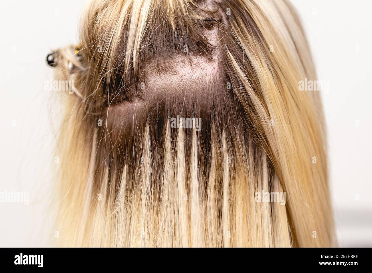 Haarverlängerungen Korrektur Verfahren. Friseur macht Haarverlängerungen zu blonden Haar Dame in einem Schönheitssalon Stockfoto