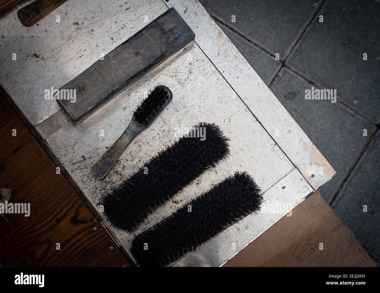 Schuhreinigungsbürsten und Creme eines Schuhreinigers auf der Straße. Stockfoto