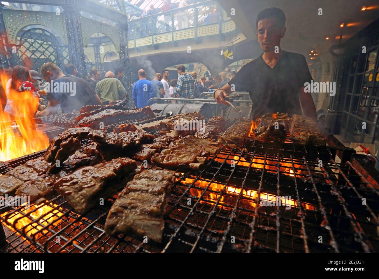 Meatopia in Tobacco Dock in London. Mann Grillen auf Grill . Stockfoto