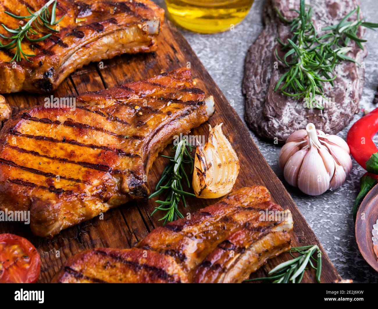 Gekochtes gegrilltes Fleisch Schweinefleisch, Rind, Lamm, Kotelett, Schneidebrett, Gewürze, Tomaten, Stockfoto