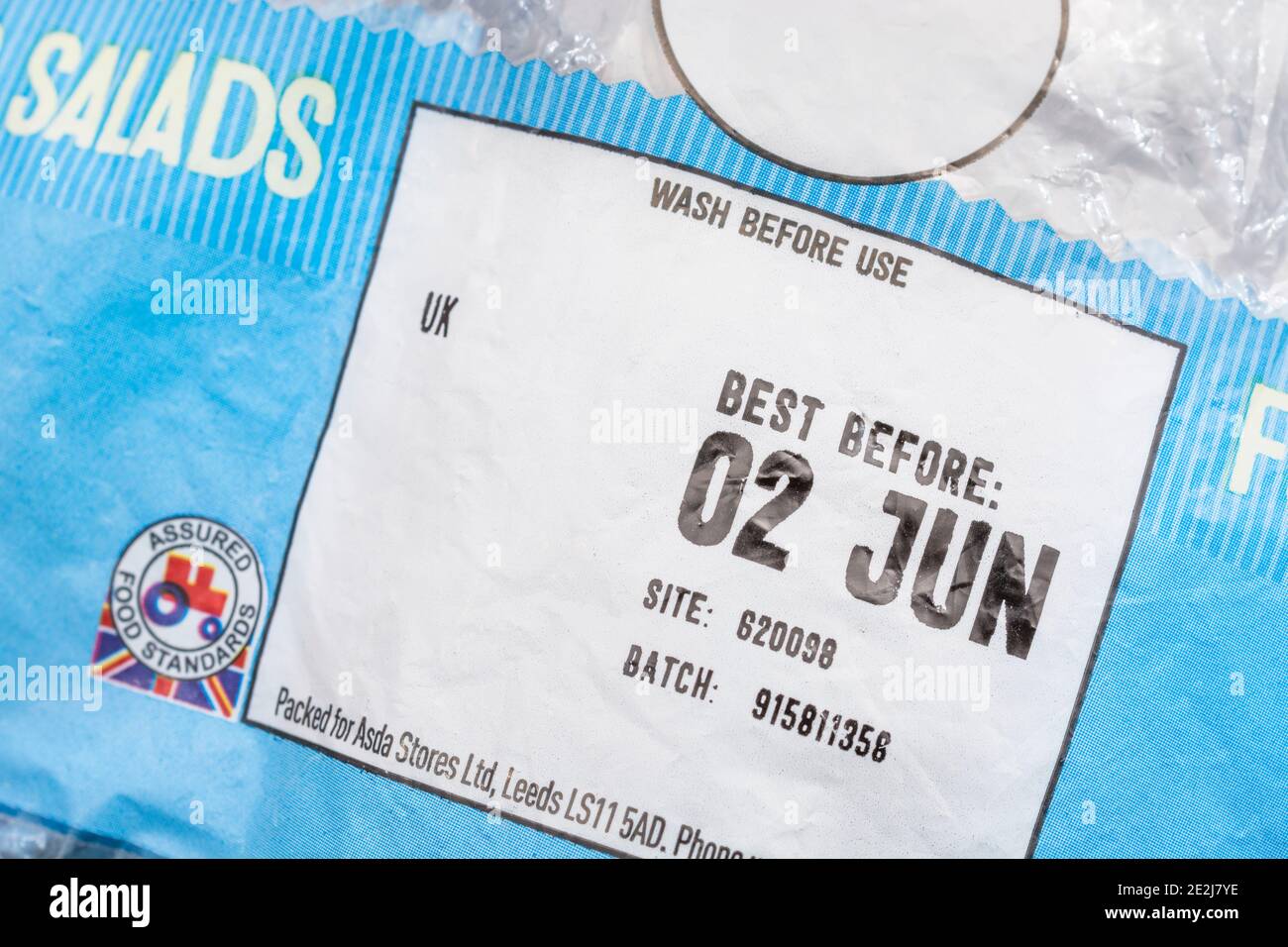 Nahaufnahme des Essens Best Before Date / BBD auf Plastikfolie von ASDA British Baby Potatoes. Unnötige Lebensmittelverschwendung & Wegwerfen von Lebensmitteln Konzept. Stockfoto