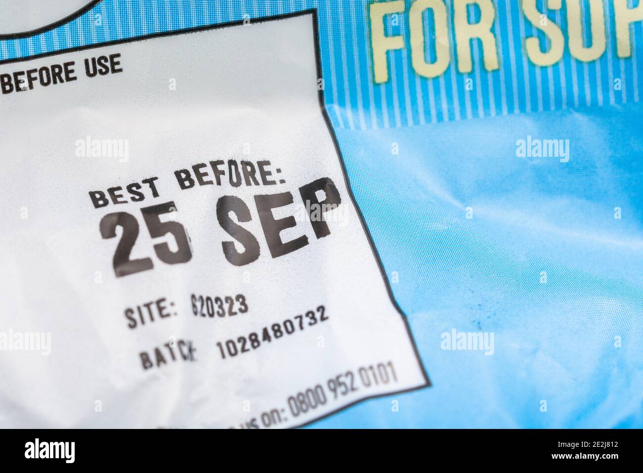 Nahaufnahme des Essens Best Before Date / BBD auf Plastikfolie von ASDA British Baby Potatoes. Unnötige Lebensmittelverschwendung & Wegwerfen von Lebensmitteln Konzept. Stockfoto