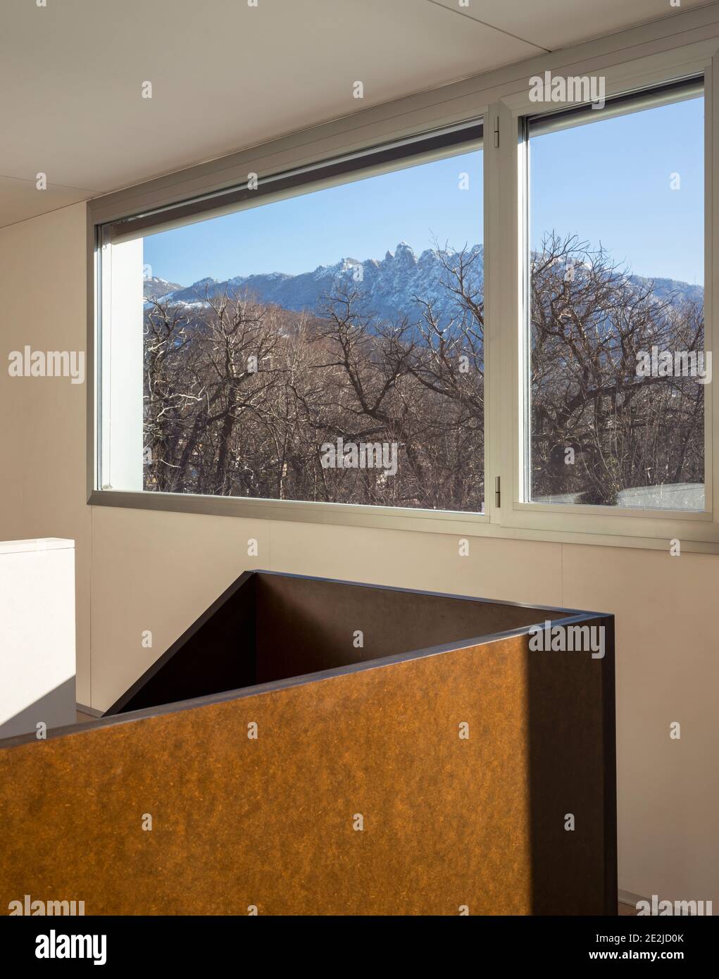 Detail des Fensters mit Blick auf die Natur in einer Winterzeit. Der Himmel ist blau Stockfoto