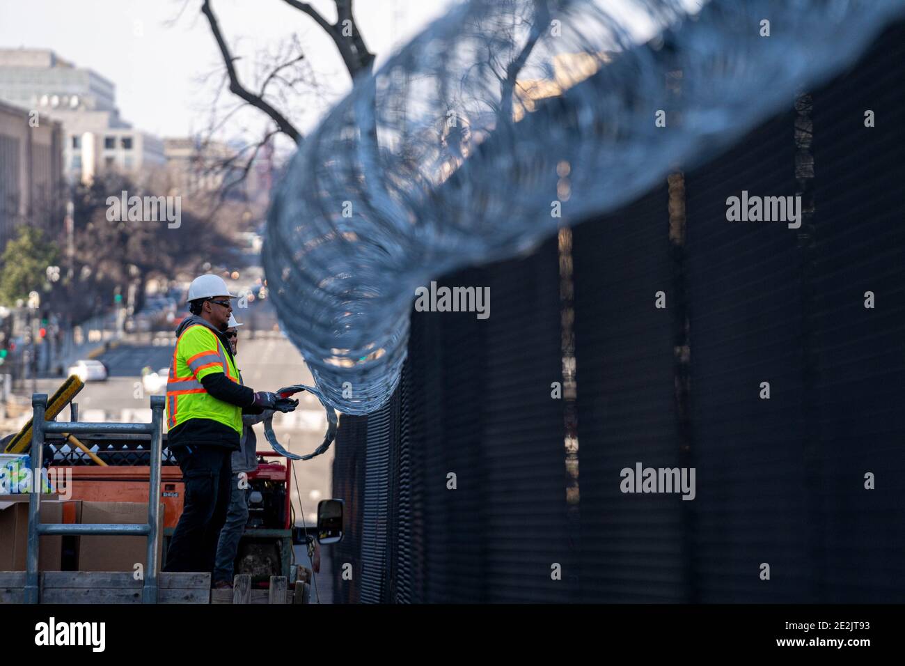 Washington, Usa. Januar 2021. Arbeiter mit Hercules-Zaun installieren am Donnerstag, dem 14. Januar 2021, Rasierdraht auf dem 8 Meter hohen Umzäunungszaun, der das US-Kapitol in Washington, DC umgibt. Die Sicherheit ist für die bevorstehende Einweihung extrem eng. Am 6. Januar brachen pro-Trump MAGA-Mobs den Sicherheitsbereich und drangen in das US-Kapitol ein. Foto von Ken Cedeno/UPI Kredit: UPI/Alamy Live Nachrichten Stockfoto