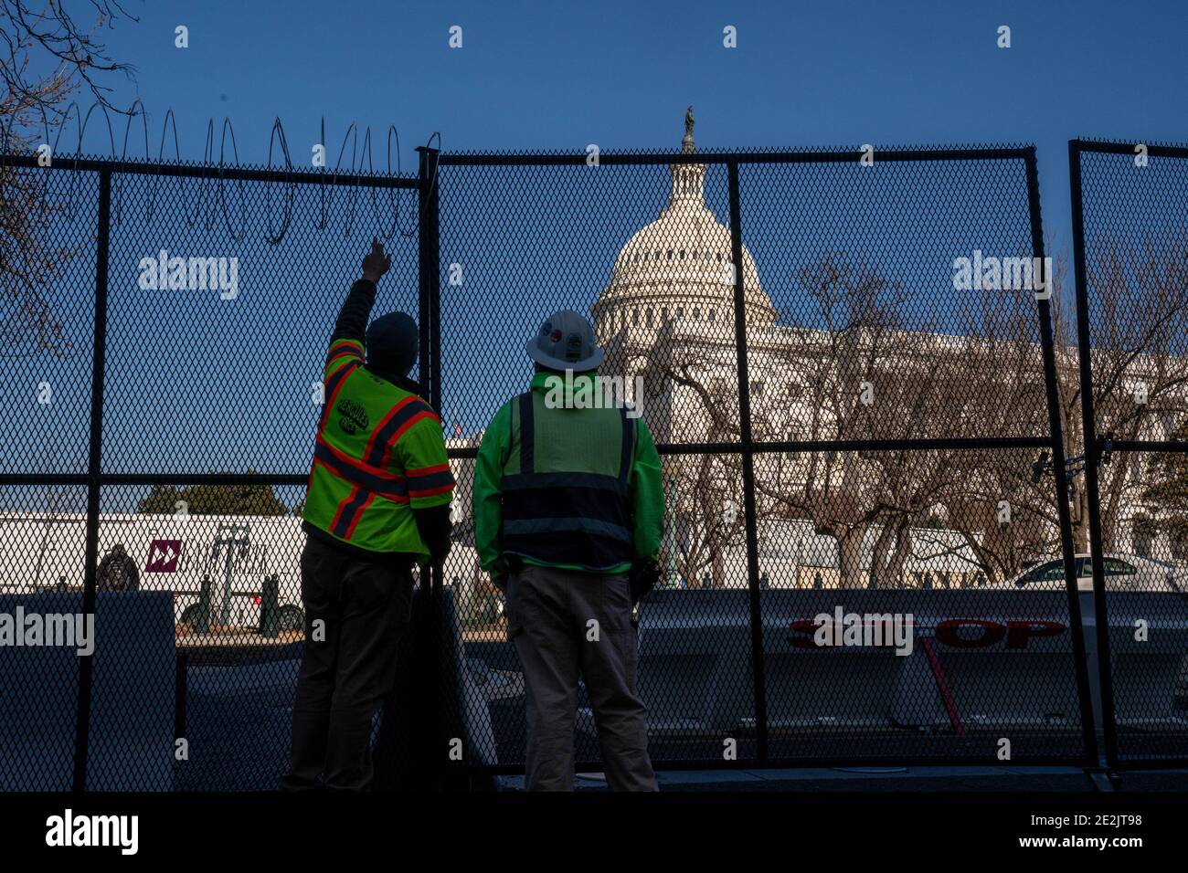 Washington, Usa. Januar 2021. Arbeiter mit Hercules Zaun installieren am Donnerstag, dem 14. Januar 2021, Rasierdraht auf dem 8 Meter hohen Umzäunungszaun, der das US-Kapitol in Washington, DC umgibt. Die Sicherheit ist für die bevorstehende Einweihung extrem eng. Am 6. Januar brachen pro-Trump MAGA-Mobs den Sicherheitsbereich und drangen in das US-Kapitol ein. Foto von Ken Cedeno/UPI Kredit: UPI/Alamy Live Nachrichten Stockfoto