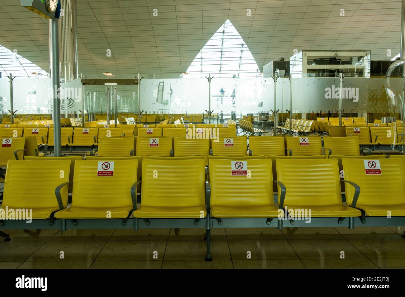 Dubai, VAE, 20.11.2020. Reihen leerer Sitzplätze am DXB-Terminal des Dubai International Airport mit Hinweisschildern für nicht-Sitzplätze aufgrund einer Coronavirus-Pandemie. Stockfoto