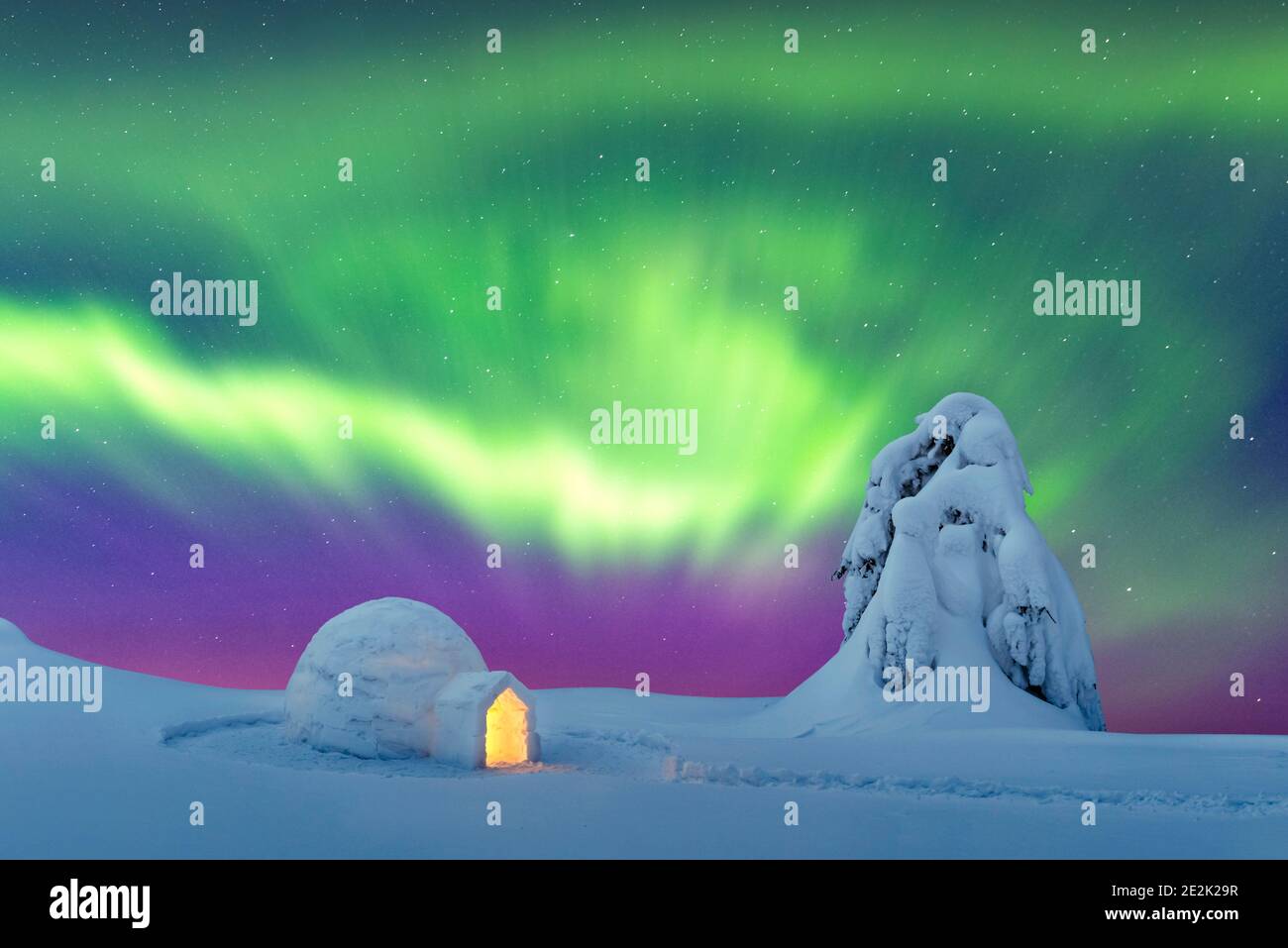 Aurora Borealis. Nordlichter im Winter Berge. Winterliche Szene mit glühenden Polarlichter und verschneiten Iglu Stockfoto