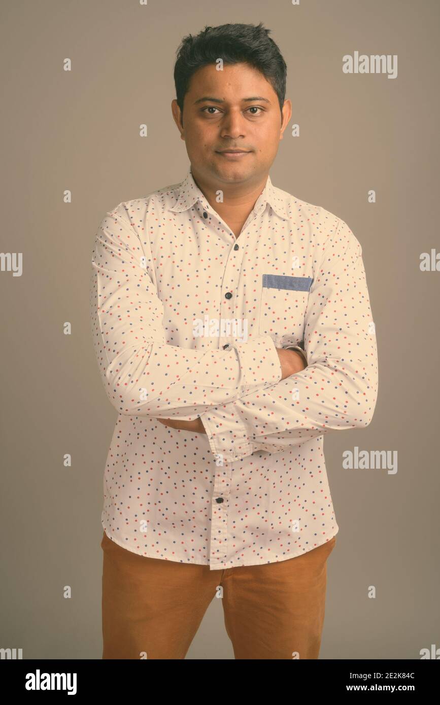 Junge indische Geschäftsmann gegen grauer Hintergrund Stockfoto