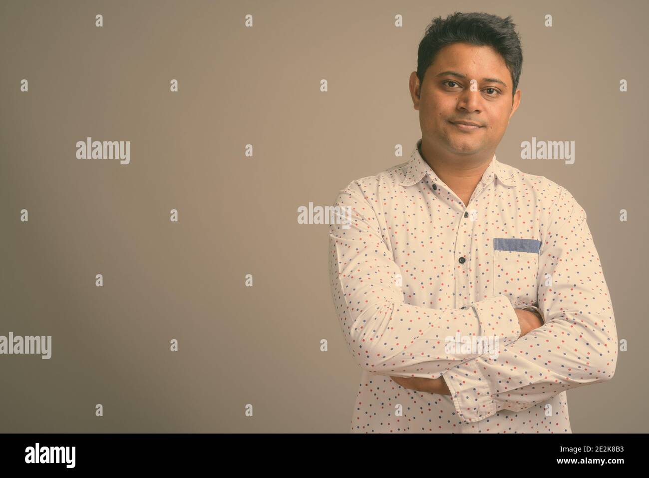 Junge indische Geschäftsmann gegen grauer Hintergrund Stockfoto