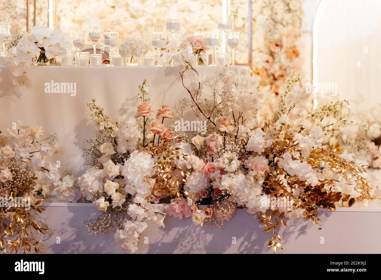 Blumen Dekoration bei der Hochzeit. Helle Blumen Hintergrund. Weiße Kerzen auf dem Tisch Stockfoto