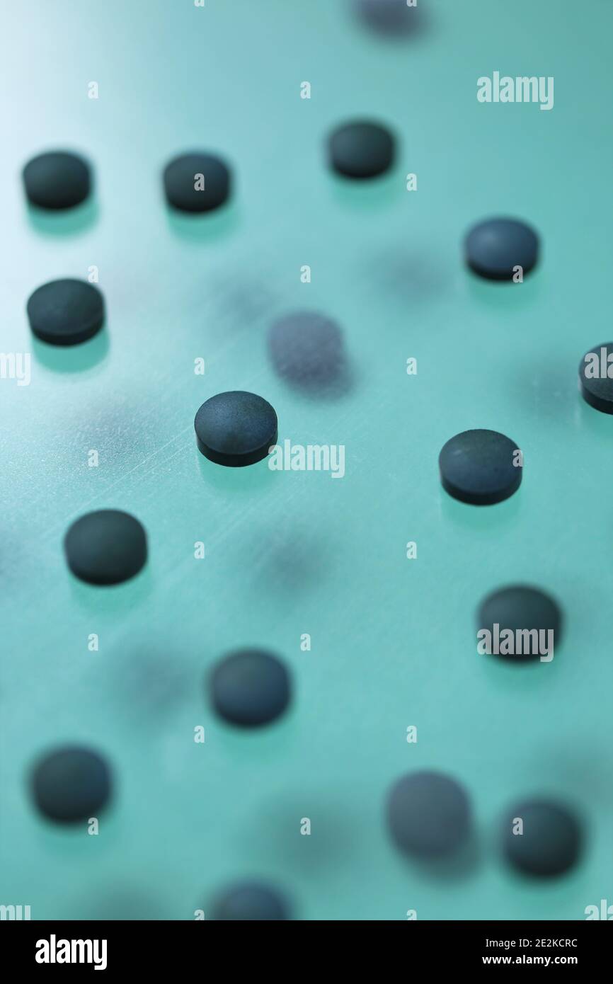 Spirulina Algentabletten.Nahrungsergänzungsmittel. Spirulina Pillen auf einem türkisfarbenen Hintergrund gesetzt.Super Essen. Gesunde Bio-Algen.gesunde Lebensweise. .Trocken Stockfoto