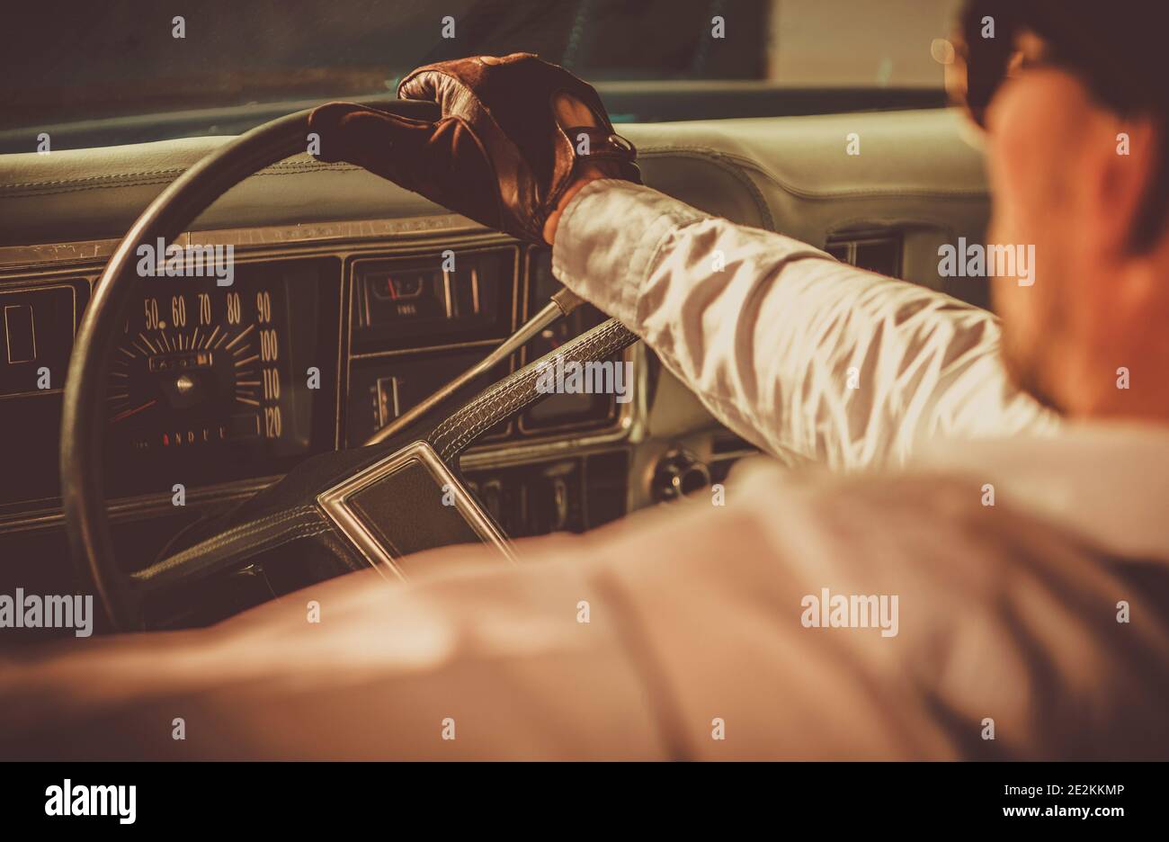 Oldtimer-Fahrer. Kaukasische Männer in seinen 40er Jahren tragen Vintage Lederhandschuhe fahren sein gealtertes Fahrzeug. Geschichte der Automotive Theme. Stockfoto