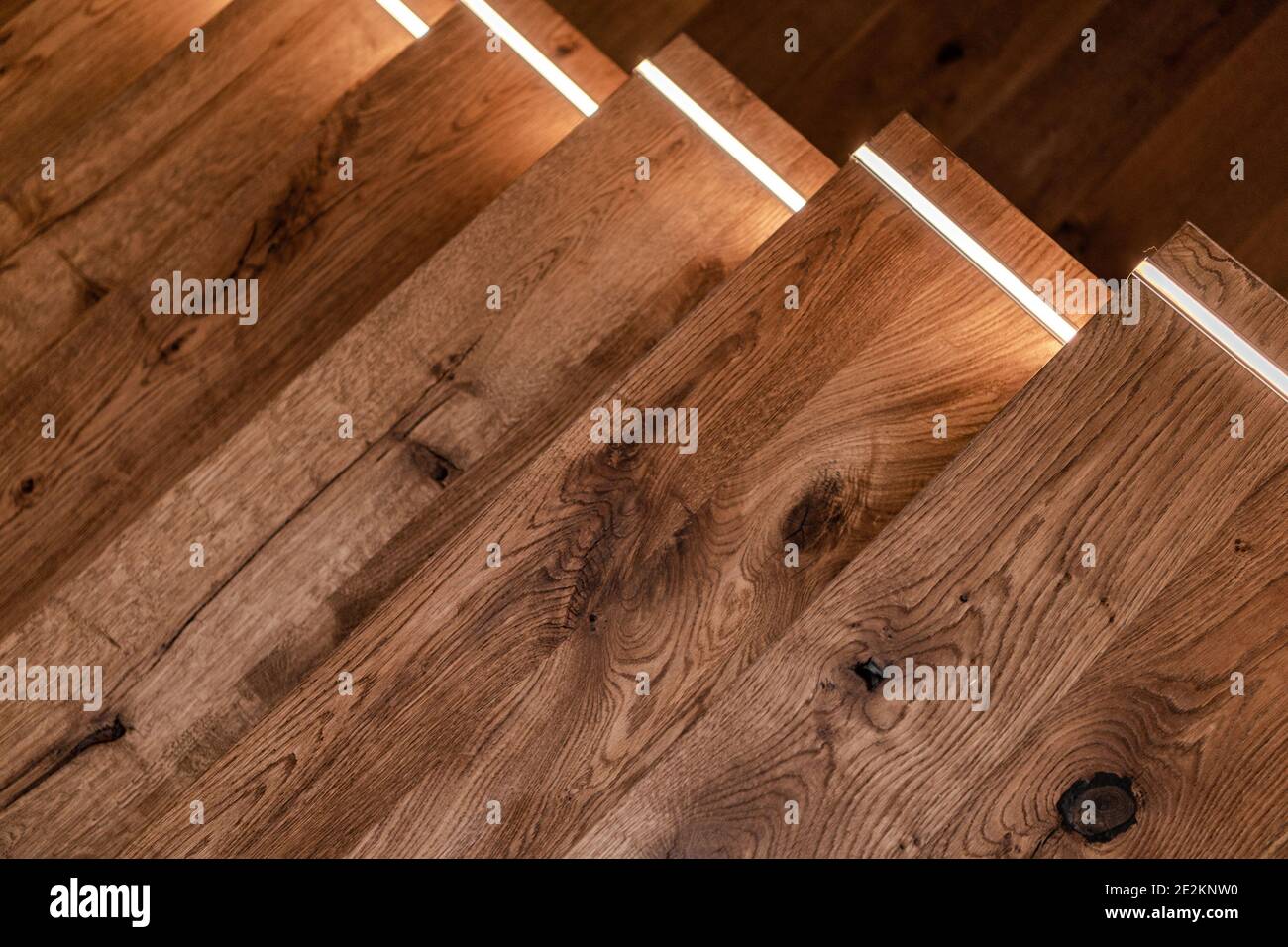 Moderne Wohngebäude Dunkle Holztreppe mit LED Beleuchtung Close Up Foto. Treppenbeleuchtung. Stockfoto