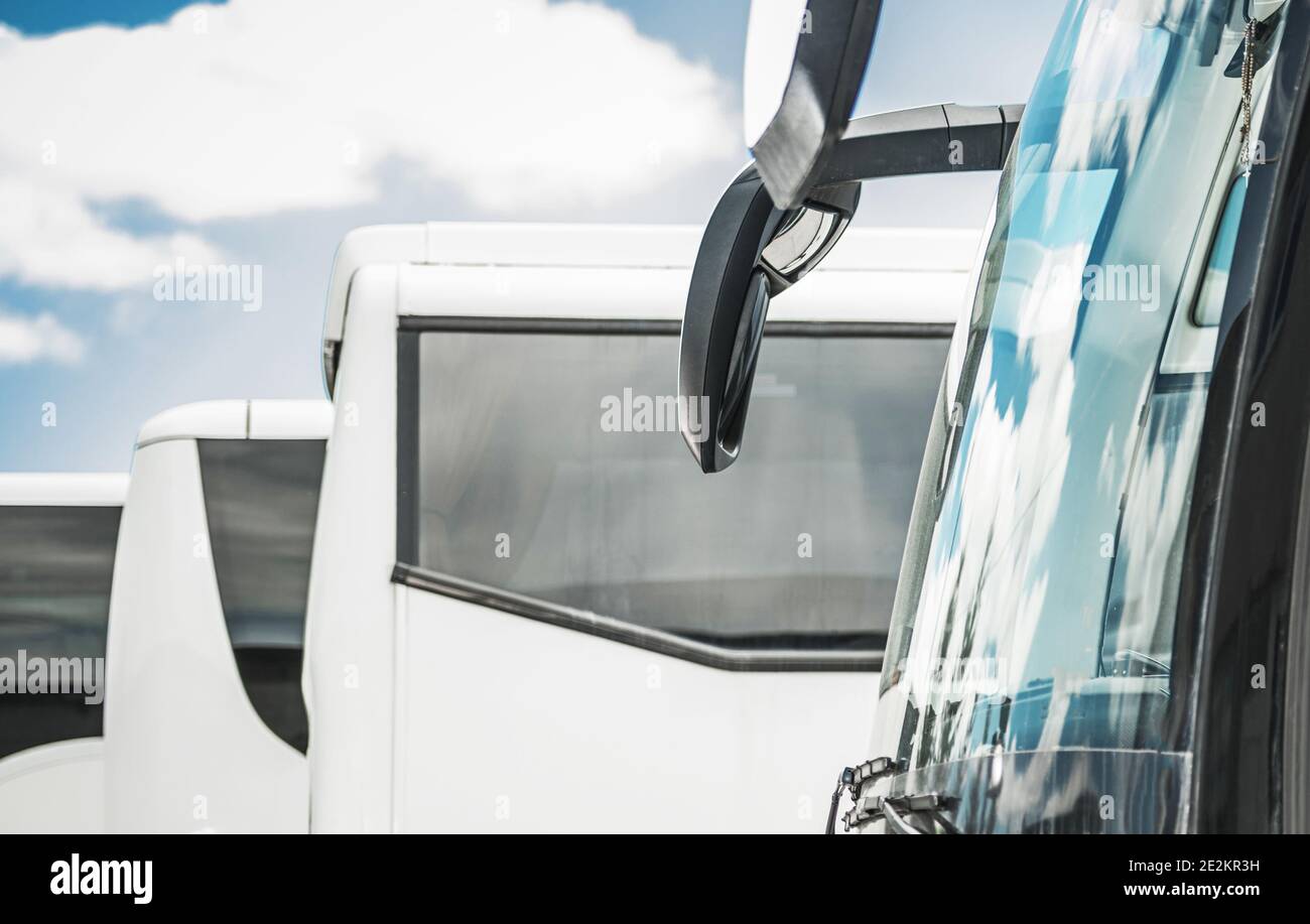 Industrie- und Geschäftsthema. Reisebusse Öffentliche Verkehrsmittel Business. Wenige moderne weiße Busse auf dem Parkplatz warten auf andere Routen. Stockfoto