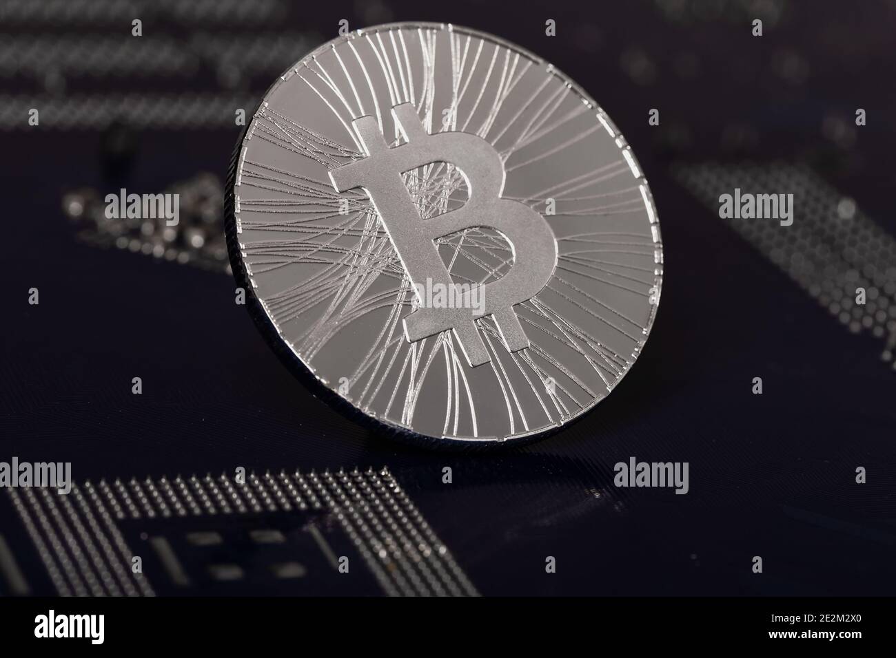 Krypto-Währung Silbermünze mit Bitcoin-Symbol auf dem Hintergrund einer elektronischen Mikroschaltung. Kryptowährung Konzept. Stockfoto