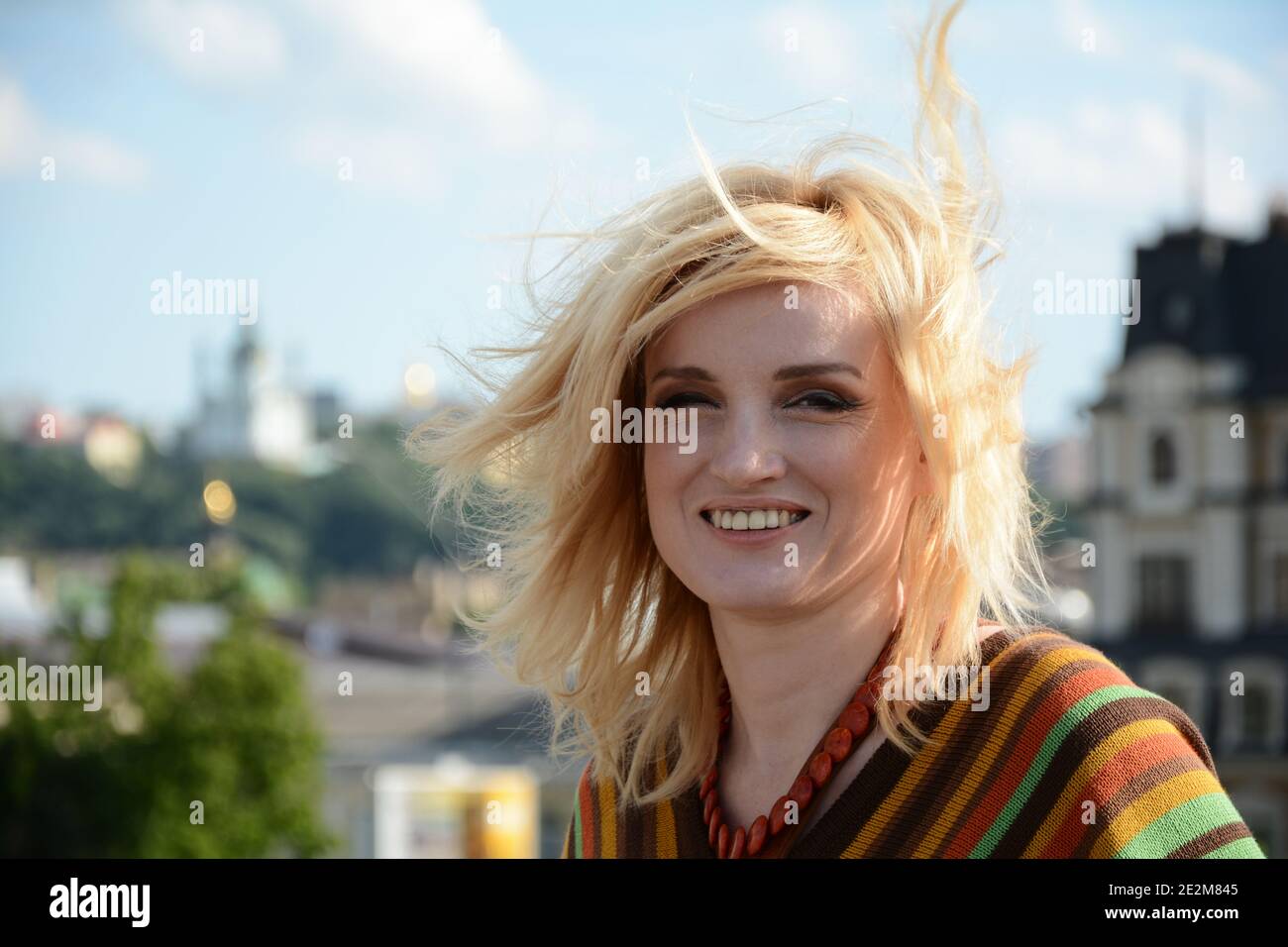 Eine Frau in 1970-Stil Kleidung lächelt im Freien Stockfoto