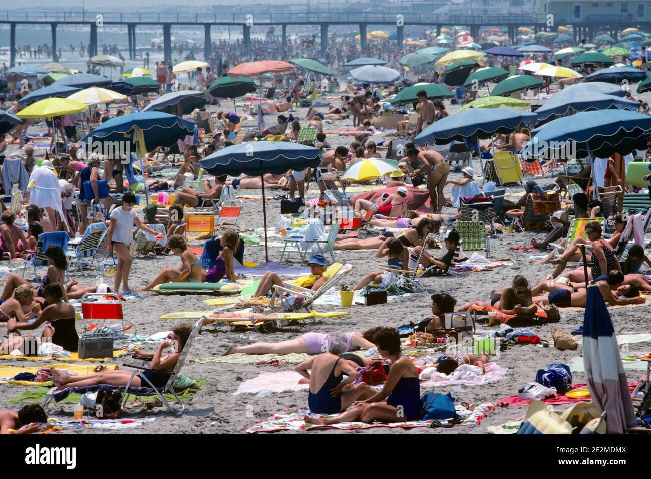 80ER JAHRE ÜBERFÜLLT SOMMER ÖFFENTLICHEN STRAND ATLANTIC CITY NEW JERSEY USA - KB26059 NET002 HARS PERSONEN MÄNNER RISIKO REGENSCHIRME SONNENBADEN SAMMELN IM SOMMER IST EIN AUSFLUG AUSSERHALB DES STÄDTISCHEN STADTZENTRUMS IM HOCHWINKEL MÖGLICH ERHOLUNG ERHOLUNG ERHOLUNG STRAND STRÄNDE URLAUB NJ JERSEY KÜSTE MID-ATLANTIC KONZEPTIONELL OSTKÜSTE FLUCHT SANDIG VERSCHIEDENE NEW JERSEY ABWECHSLUNGSREICHE ZUSAMMENARBEIT ENTSPANNUNG JAHRESZEIT SONNENANBETER DRÄNGEN URLAUB ALTMODISCH Stockfoto