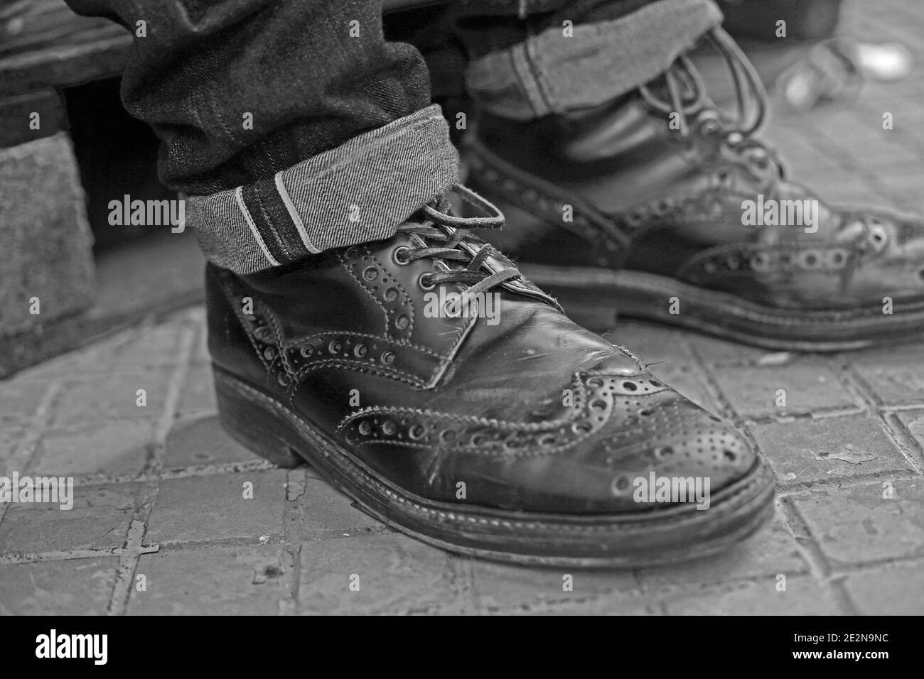 Nahaufnahme eines Mannes, der ein Paar Brogues trägt Schuhe und Jeans aus Roh-Denim Stockfoto