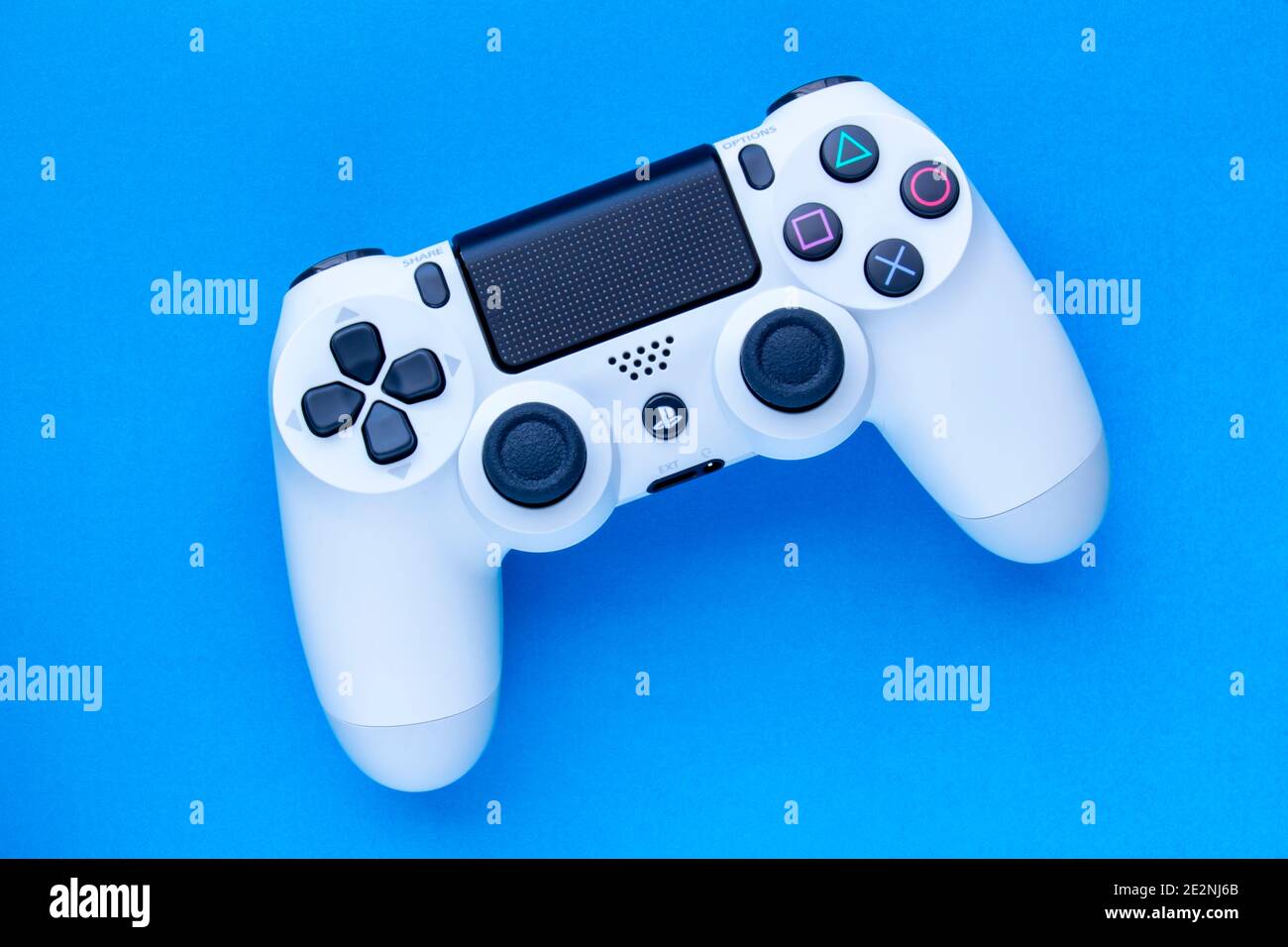 Calgary, Alberta, Kanada. Januar 06 2021. Ein weißer PlayStation 4 DualShock 4 Wireless Controller - Glacier White auf blauem Hintergrund. Stockfoto