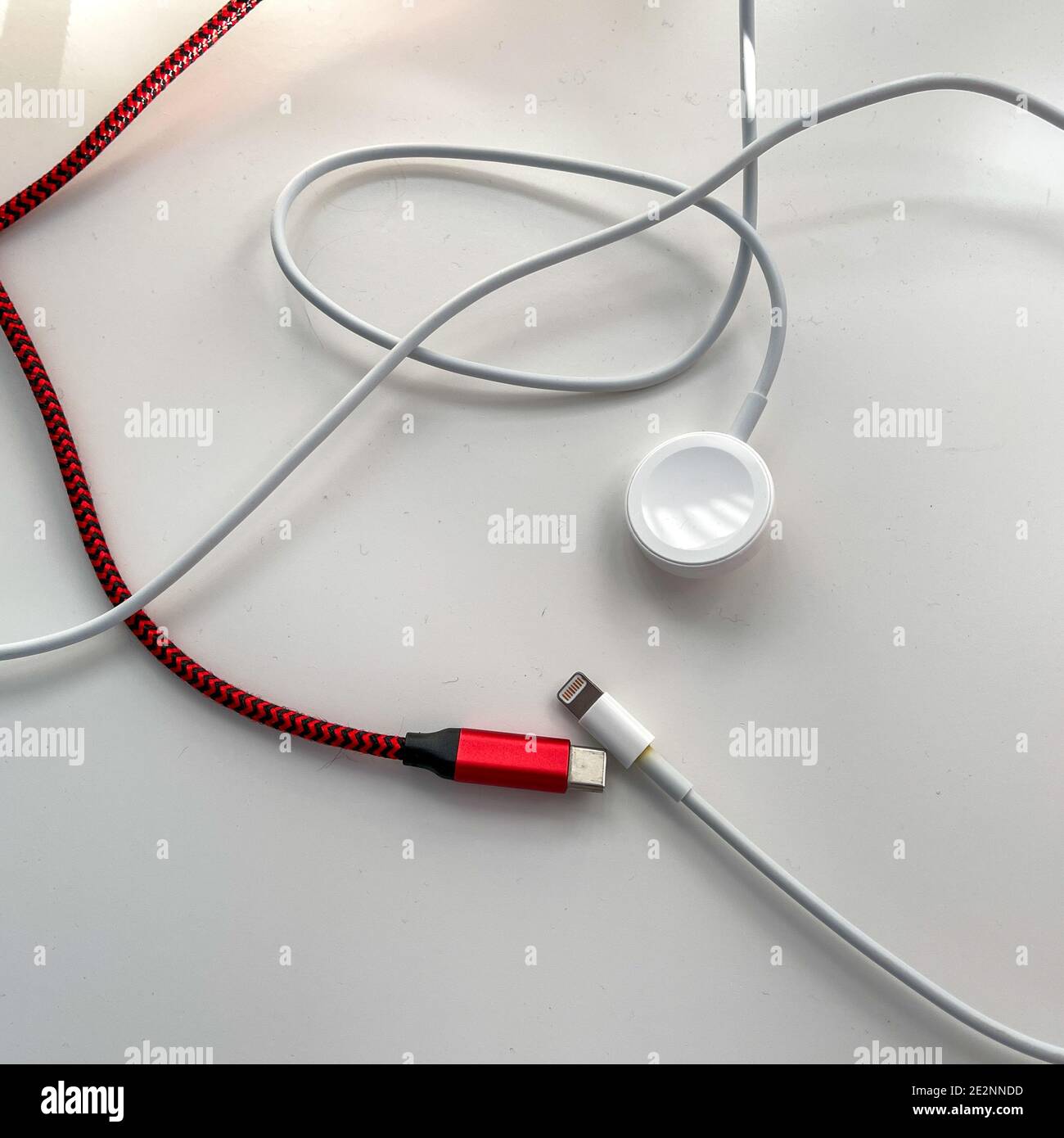 USB c, Uhr und Handy-Ladekabel auf weißem Hintergrund. Stockfoto