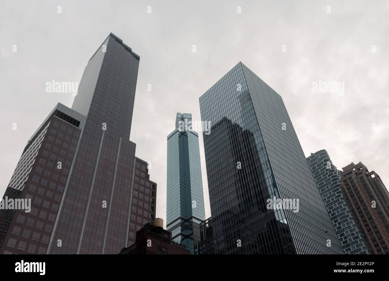 Die Wolkenkratzer der Stadt New york lehnen sich in einem weißen, wolkigen Himmel in den Fluchtpunkt, um eine dreieckige, geometrische Architekturszene auf der Skyline zu schaffen Stockfoto