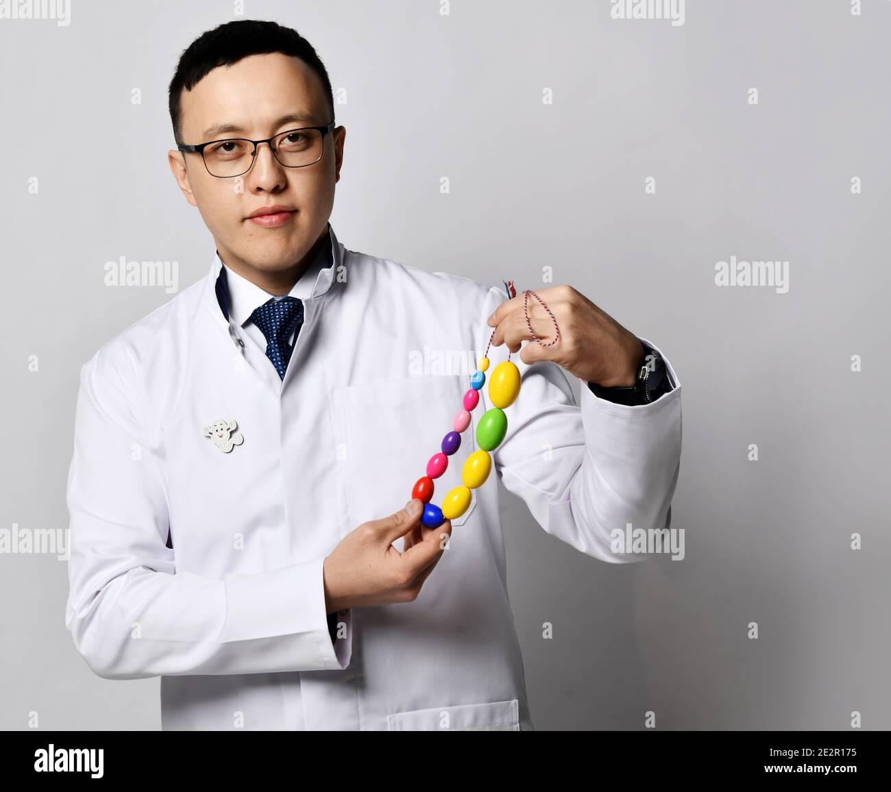 Urologischer proktologischer Ansatz. Mann Arzt Urologe oder Proktologe in weißen medizinischen Kleid hält zeigt männlichen Hoden Werkzeug Stockfoto