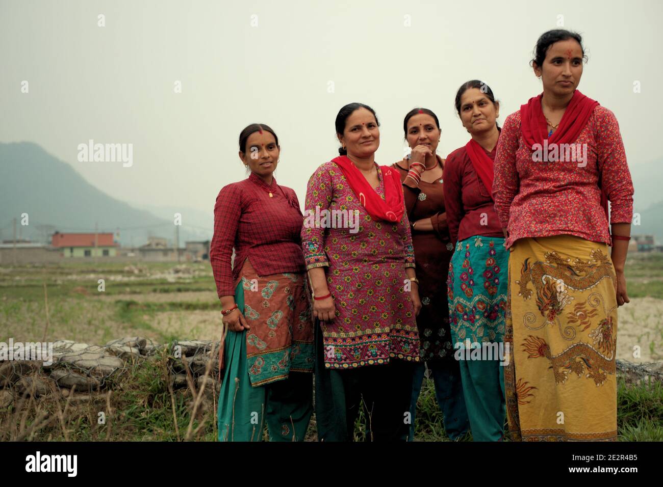Portrait von Frauen, Dorfbewohnern von Khahare, wie sie in der Nähe einer Gabionenmauer auf der Seite der Harpan Khola Aue im Kaski Bezirk, Gandaki, Nepal stehen. Diese Frauen waren Überlebende von Überschwemmungen und Erdrutschen, die durch sintflutartige Regenfälle im Bhaudare Tamagi Gebiet verursacht wurden, wenige Monate nach den Erdbeben von 2015 (April-Mai 2015) in Nepal. Stockfoto
