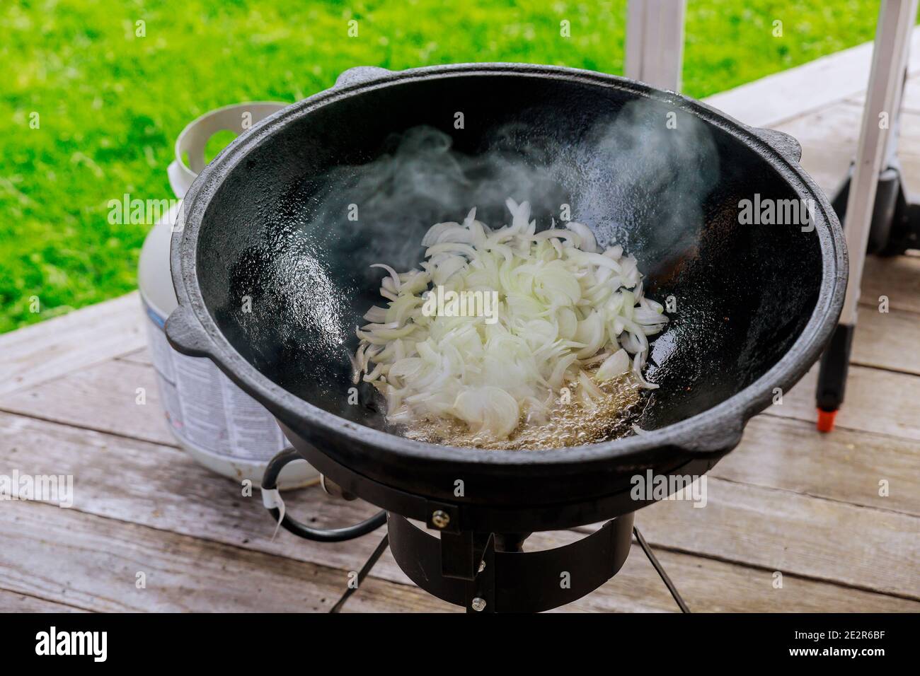 Zwiebel in einem Kessel rösten. Zubereitung leckeres Essen draußen. Stockfoto