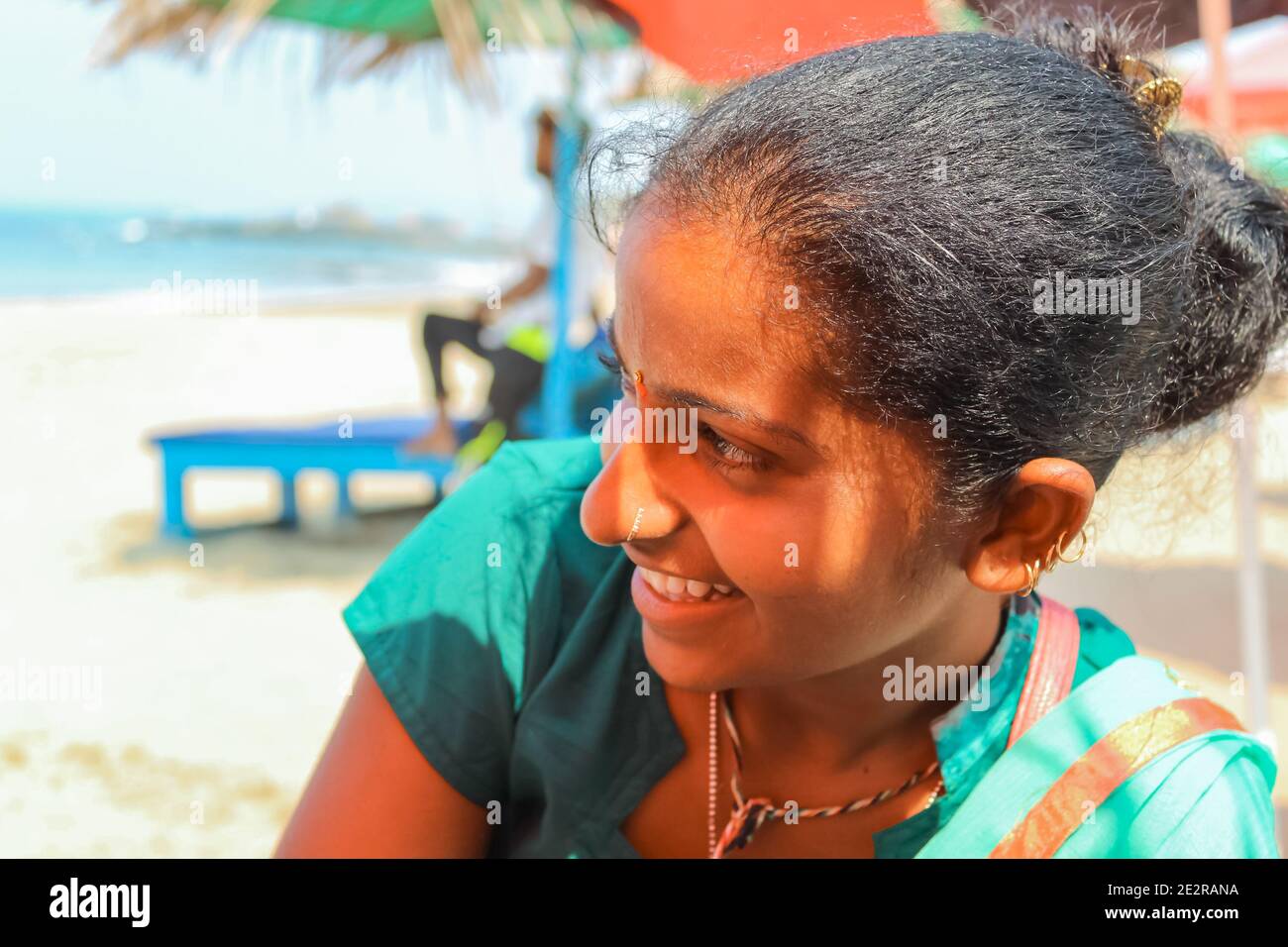 Ein junges indisches Mädchen in einem Sari-Kleid lächelt mit einem schüchtern. Siolim, Goa/Indien - Oktober 28,2018. Selektiver Fokus, Reisefoto, Straßenfoto, Konzeptfoto i Stockfoto