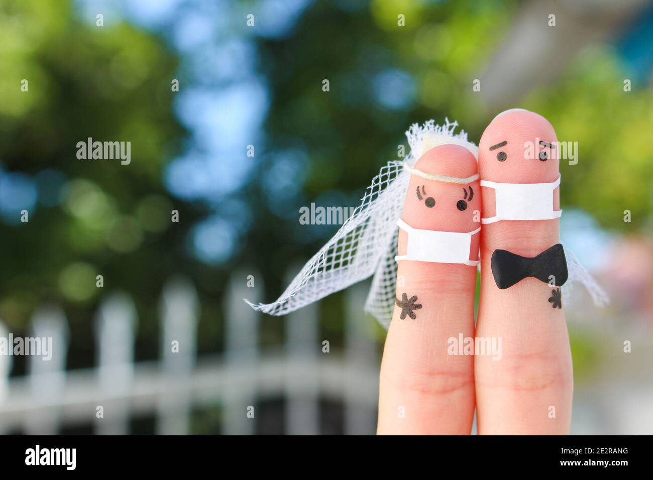 Finger Kunst des glücklichen Paares in medizinischer Maske von COVID-2019. Konzept der Hochzeitszeremonie. Stockfoto
