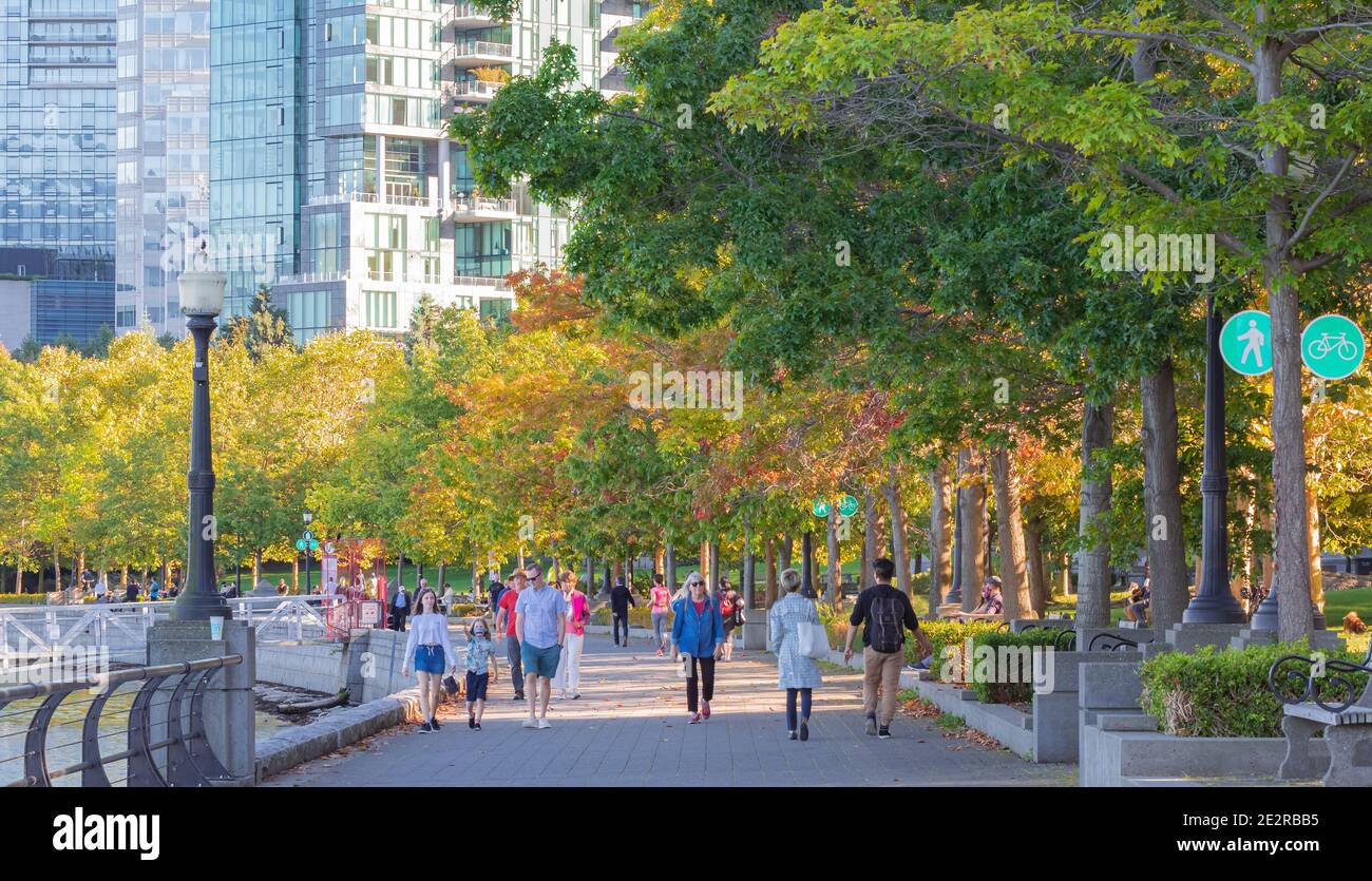 Menschen, die entlang der Promenade am Hafen in Vancouver City, BC, Kanada-29. September 2020. Selektiver Fokus, unscharf, Reisefoto, Straßenansicht Stockfoto