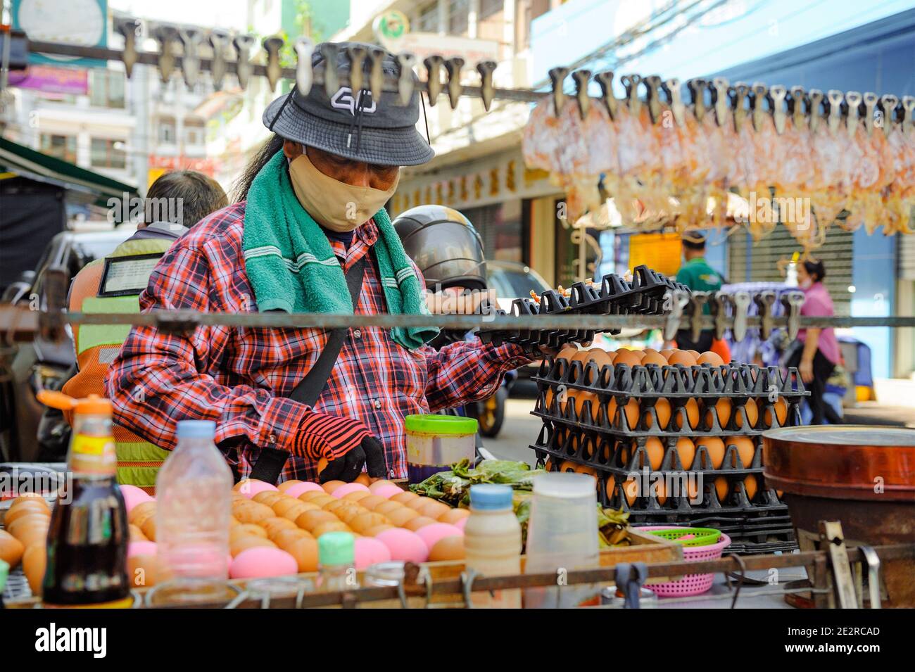 China Town, Bangkok, Thailand - 14. Nov. 2020: Ein Street Food Verkäufer muss immer eine schützende Gesichtsmaske tragen, während er sein Essen verkauft. Stockfoto
