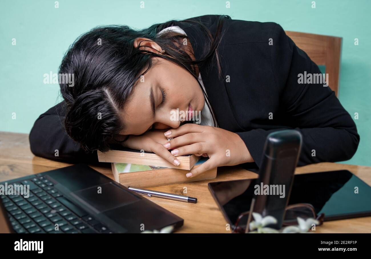 Junges Mädchen ruht oder schläft mit dem Kopf auf einigen Bücher Stockfoto