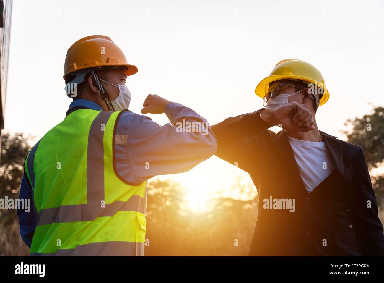 Asiatische Industrie Bauarbeiter und Vorarbeiter tragen Hygiene Gesicht Maske Ellenbogen Beule Grußansage Anpassung Coronavirus oder Covid-19 zu verhindern Verteilen Stockfoto