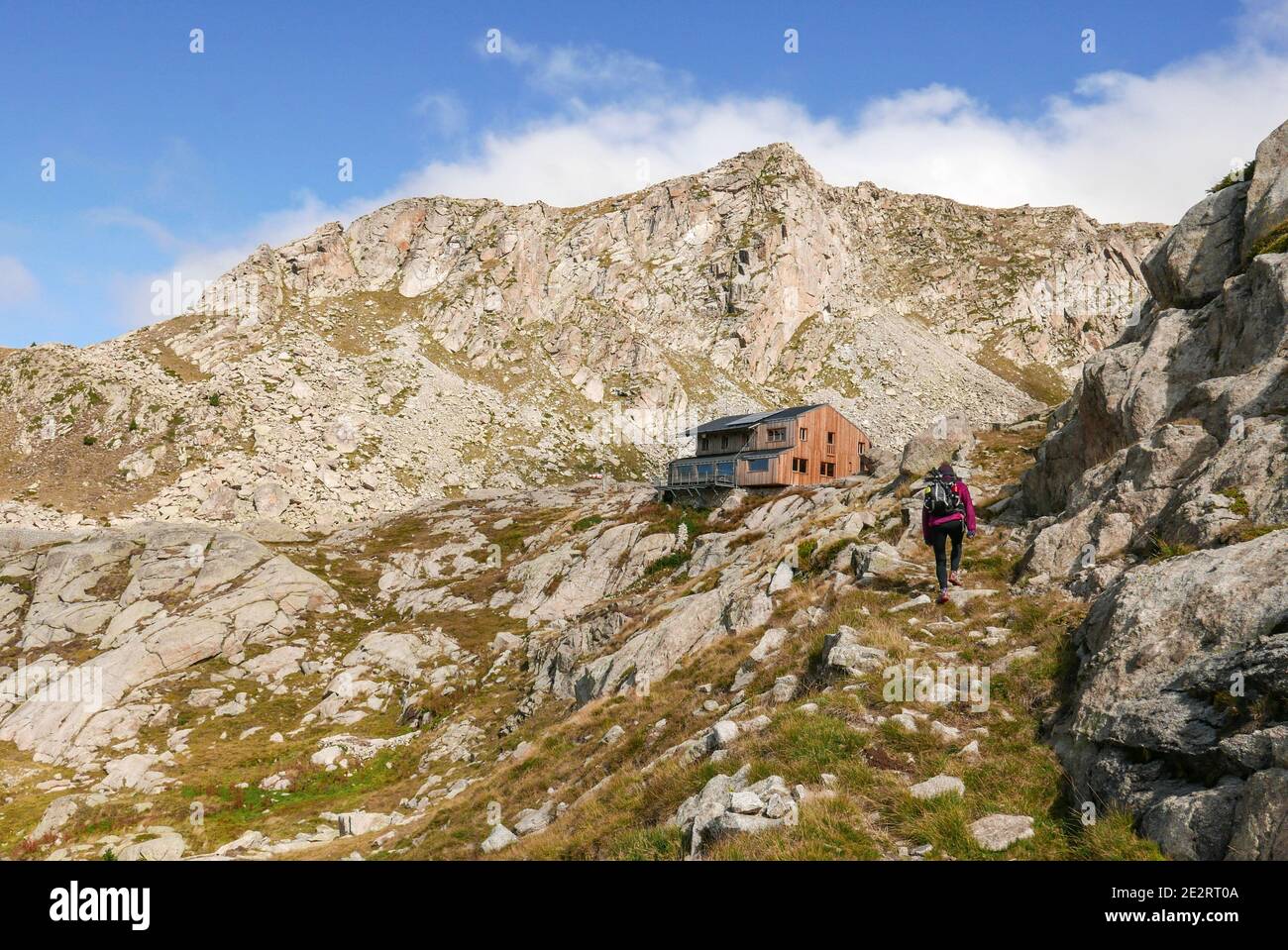 Spanien, Katalonien: Vall Fosca. Nationalpark Aoguestortes y Sant Maurici. Wanderer, Frau mit Rucksack und ein Paar Wanderstöcke kommen in Colomin an Stockfoto