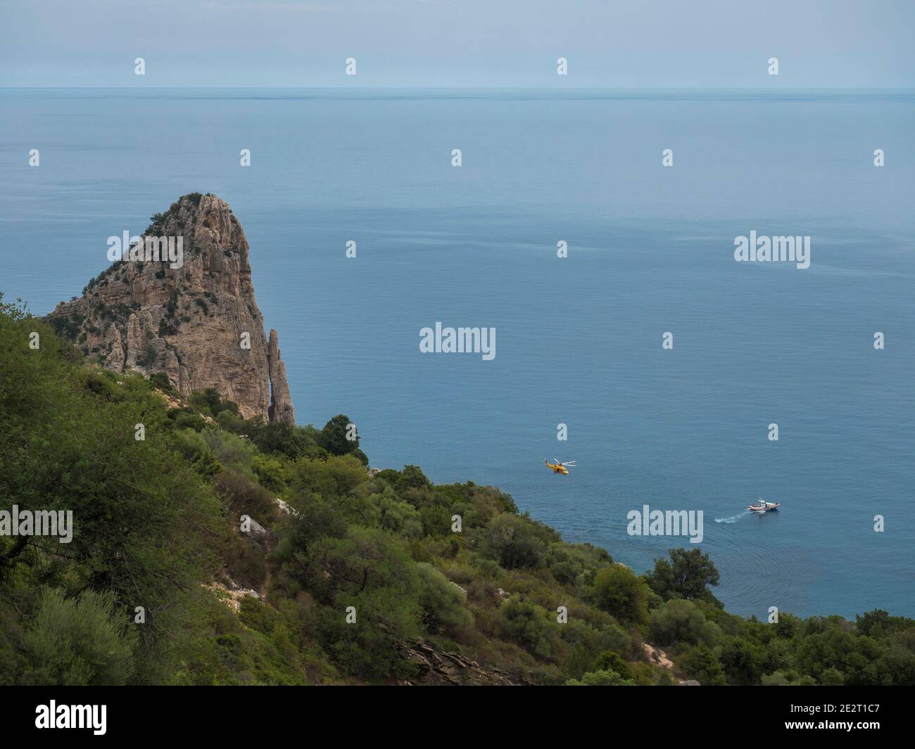 Blick auf Pedra Longa, Kalksteinsäule an der Küste Golf von Orosei mit Rettungsboot und Hubschrauber. Sardinien, Italien Stockfoto