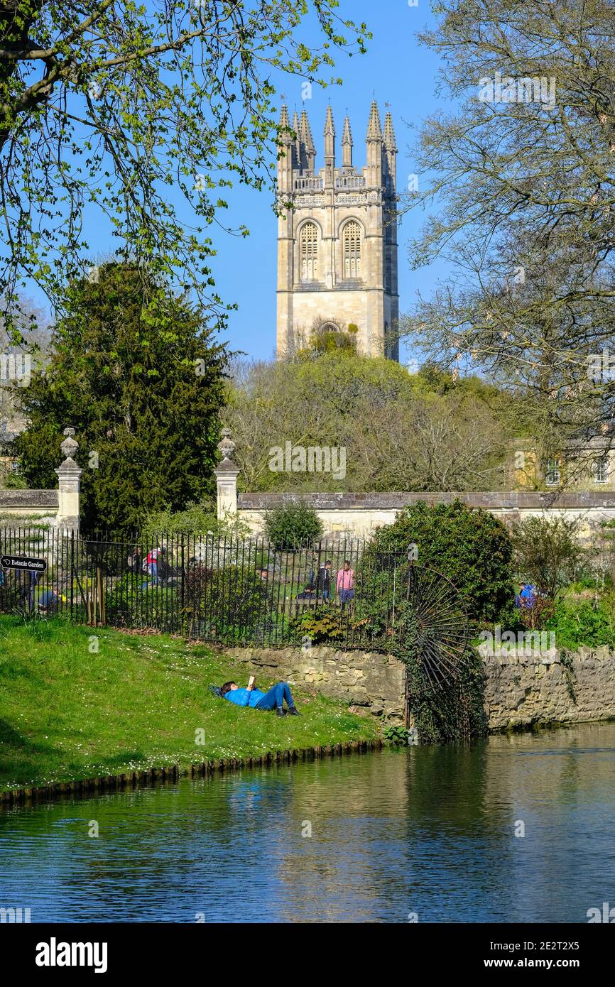 Oxford, Großbritannien. Frau liest ein Buch des Rover Cherwell mit Merton College Chapel im Hintergrund. Stockfoto