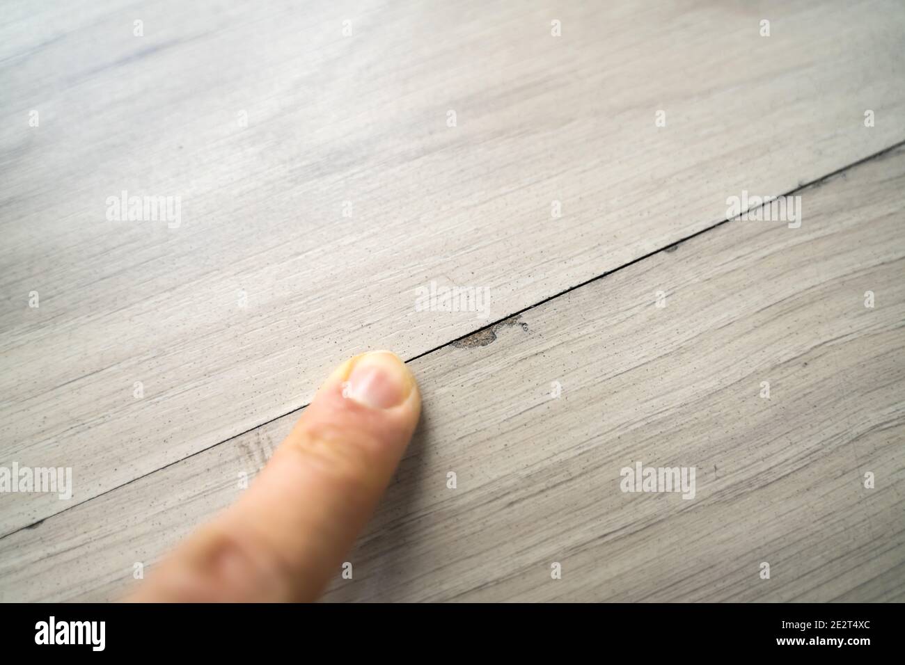 Hand Zeigt Auf Beschädigte Alte Laminat Bodenbelag Oberfläche Zu Hause Stockfoto