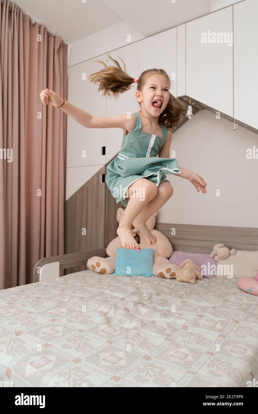 Glücklich lustige kleine Kind Mädchen in Bewegung springen auf Bett allein  Fliegen in der Luft Gefühl Freude, fröhlich niedlich aktiv Kind Spaß im  Schlafzimmer spielen Stockfotografie - Alamy