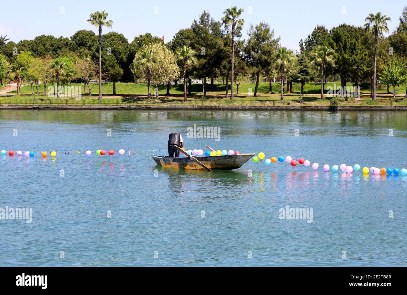 Nicht identifizierter Mann, der neue Ballons zum String auf dem Fluss hinzufügt In Adana, Türkei Stockfoto