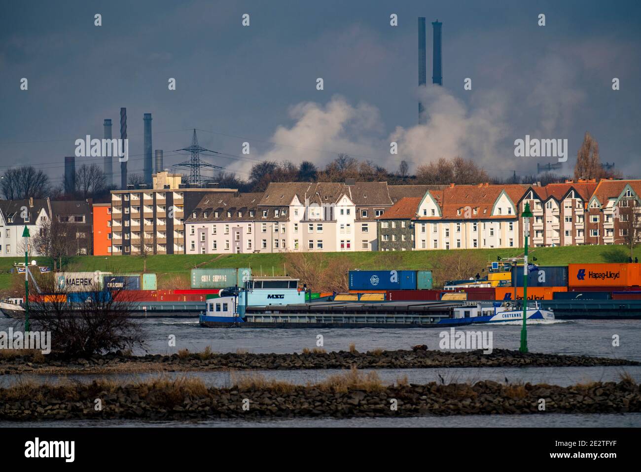 Der Rhein bei Duisburg, Häuser am Rheindeich, Laar, thyssenkrupp Steel Stahlwerk in Bruckhausen, Frachtschiff, Duisburg, NRW, Germa Stockfoto