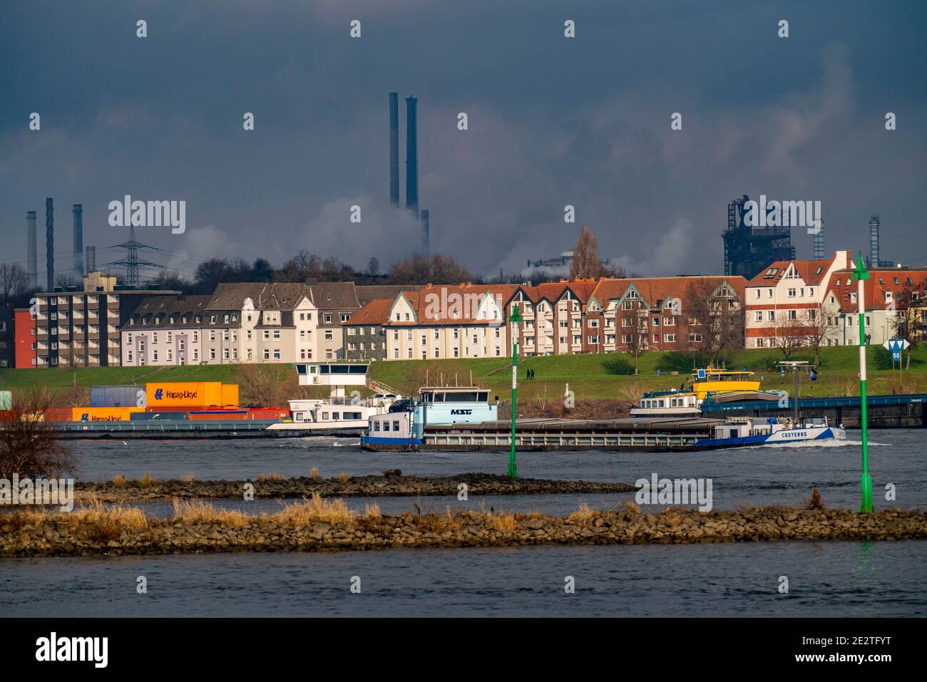 Der Rhein bei Duisburg, Häuser am Rheindeich, Laar, thyssenkrupp Steel Stahlwerk in Bruckhausen, Frachtschiff, Duisburg, NRW, Germa Stockfoto