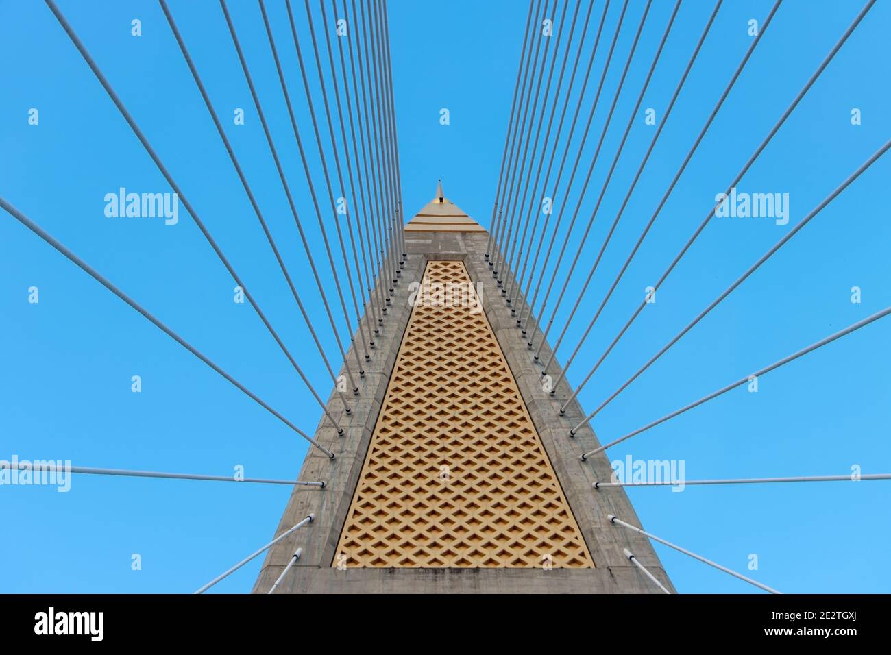 Betonbrücken-Pylon mit parallelen Leitungen aus Stahlseil. Durchgang unter dem Stützturm der Kabelbrücke. Konstruktion Kabelgestabebrücke aga Stockfoto