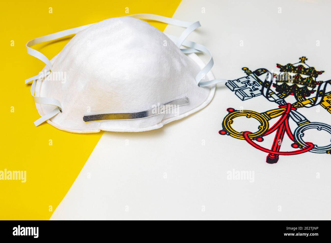 Vatikanstadt Staatsflagge und N95 Gesichtsmaske. Konzept der Covid-19 Coronavirus-Sperre, Reiseverbot und Gesundheitskrise Stockfoto